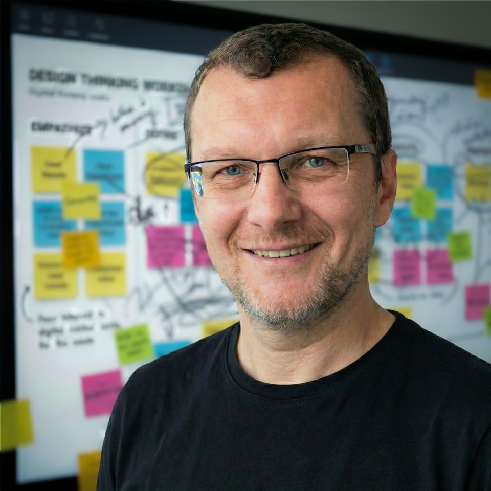 Pavel Bukengolts standing in front of a collaborative workshop board